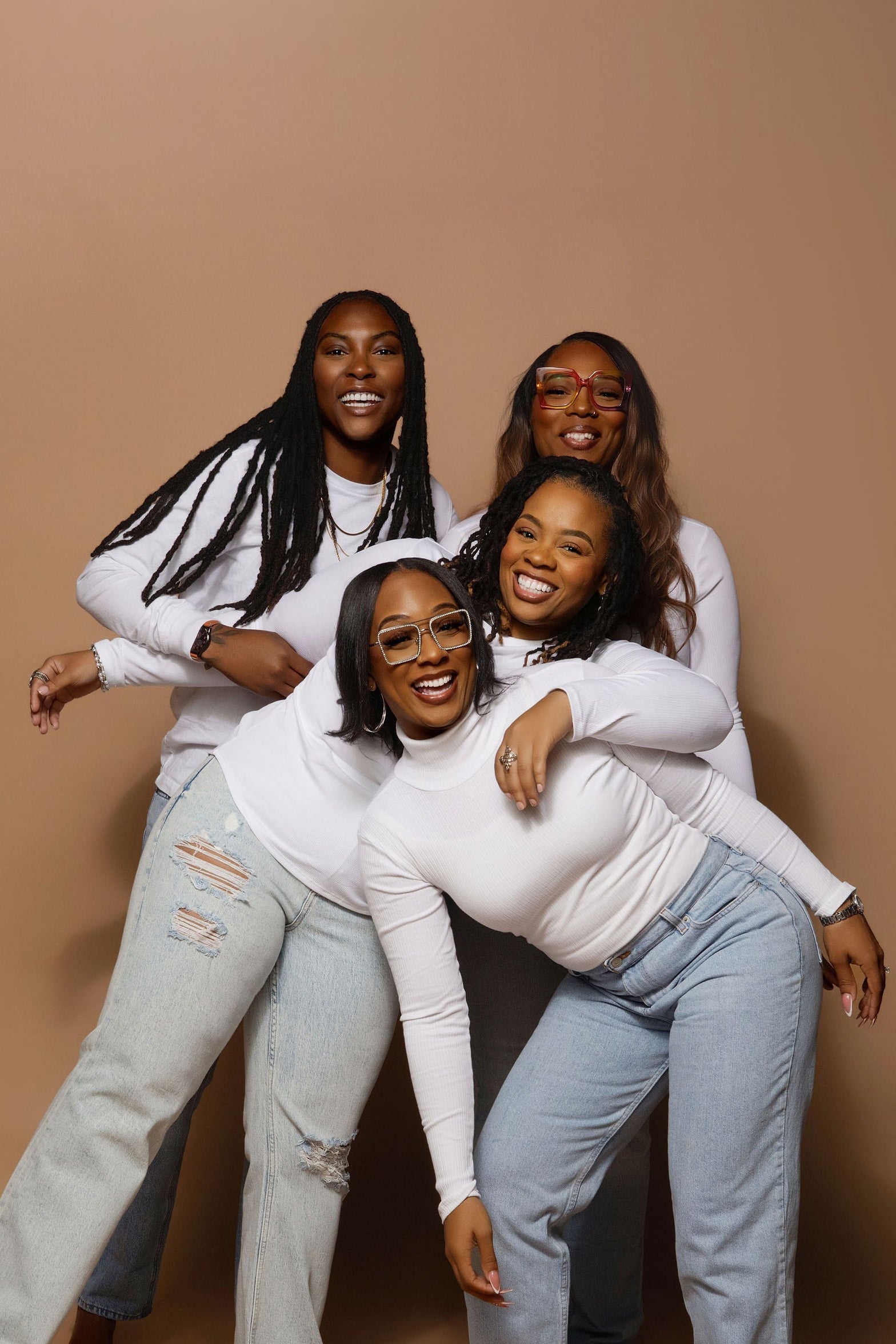 Four women posing together on a beige background- probiotics for vaginal care