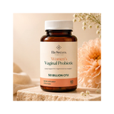 Bottle of BioSisters Women's Vaginal Probiotic on a wooden surface with flowers in the background